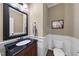 Charming powder room featuring dark wood vanity with granite countertop and stylish wainscoting at 512 Hallburg Ct, Wake Forest, NC 27587