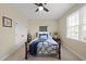 Neutral-toned bedroom with a metal bed frame, ceiling fan, natural light from a window, and a closet at 512 Hallburg Ct, Wake Forest, NC 27587