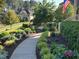 A winding walkway leads to a home's entrance, surrounded by lush greenery and landscape lighting at 512 Hallburg Ct, Wake Forest, NC 27587