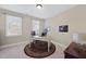 A bright office space with a desk, two windows, and neutral carpet at 512 Hallburg Ct, Wake Forest, NC 27587