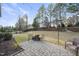 Outdoor patio with brick pavers, string lights, mature trees, and a backyard view at 512 Hallburg Ct, Wake Forest, NC 27587