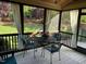 Relaxing screened porch featuring a table and chairs with views of the beautifully landscaped backyard at 512 Hallburg Ct, Wake Forest, NC 27587