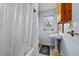 Traditional style bathroom with shower, pedestal sink, patterned tile floor, and a bright window at 529 Hillcrest Ave, Burlington, NC 27215