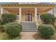 Exterior front shot of charming yellow two-story house with grey steps, mature landscaping and columns at 529 Hillcrest Ave, Burlington, NC 27215