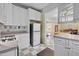 This kitchen has white cabinetry, appliances, and view into the dining room at 529 Hillcrest Ave, Burlington, NC 27215