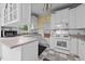 Bright kitchen features classic white cabinetry, tiled countertops, and vintage-inspired checkerboard floors at 529 Hillcrest Ave, Burlington, NC 27215