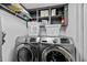 The laundry room has front load machines, overhead shelving and good lighting at 529 Hillcrest Ave, Burlington, NC 27215