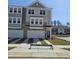 New townhome with a two-car garage, stone accents, and manicured lawn at 5320 River Reach Dr, Raleigh, NC 27616