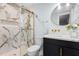 Modern bathroom featuring marble shower, brass fixtures, and a round mirror at 5812 Timber Ridge Dr, Raleigh, NC 27609