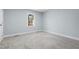 Clean and simple bedroom with gray carpet and a bright window view at 5812 Timber Ridge Dr, Raleigh, NC 27609