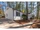 Side view of a white brick home with black accents and a well-manicured lawn at 5812 Timber Ridge Dr, Raleigh, NC 27609