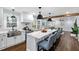 Bright, open kitchen with large island, stainless steel appliances, and modern lighting fixtures at 5812 Timber Ridge Dr, Raleigh, NC 27609