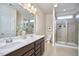 Bright bathroom with double sinks, a walk-in shower, and modern fixtures and lighting at 590 Grand Central Sta, Apex, NC 27502