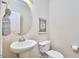 Chic powder room with a pedestal sink, round mirror, and neutral decor, perfect for guests at 590 Grand Central Sta, Apex, NC 27502