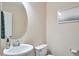 Half-bathroom featuring pedestal sink, round mirror, and neutral color scheme at 590 Grand Central Sta, Apex, NC 27502