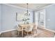 Cozy dining area featuring a modern chandelier, stylish furniture, and natural light from shuttered doors at 590 Grand Central Sta, Apex, NC 27502