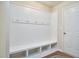 White mudroom with bench, storage cubbies, coat hooks, and a neutral wall color, perfect for organization at 590 Grand Central Sta, Apex, NC 27502