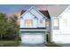 Charming two-story home featuring a white garage door and blue accents at 6000 Enclosure Way, Durham, NC 27703