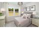 Cozy bedroom with a neutral color scheme, large windows, and comfortable furnishings at 6002 Enclosure Way, Durham, NC 27703