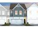 Charming townhome showcasing a two-car garage, neutral siding and a welcoming front entrance at 6002 Enclosure Way, Durham, NC 27703