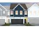 New construction townhouse with a two-car garage, dark-blue siding, and manicured landscaping at 6019 Enclosure Way, Durham, NC 27703