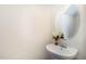 Half-bathroom with white pedestal sink, round mirror, and neutral wall color at 627 Hastings Rd, Mebane, NC 27302