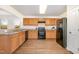 Bright kitchen featuring wooden cabinets, granite countertops, and black appliances at 627 Hastings Rd, Mebane, NC 27302