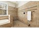 Spa bathroom featuring walk-in shower, soaking tub and neutral colored tiles at 6452 Therfield Dr, Raleigh, NC 27614