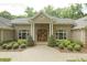 Stately brick home featuring a beautiful entrance with manicured landscaping and a circular driveway at 6452 Therfield Dr, Raleigh, NC 27614