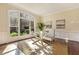 Bright home office with large arched window, hardwood floors, and modern glass desk at 6452 Therfield Dr, Raleigh, NC 27614