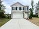 Two-story home features a large garage and a welcoming entrance at 736 Kenyon Spring Dr, Zebulon, NC 27597