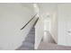 Hallway features carpeted stairs, railing and leads into a room with hard wood flooring at 736 Kenyon Spring Dr, Zebulon, NC 27597