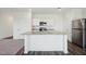 A spacious kitchen with an island, stainless steel appliances, and granite countertops at 736 Kenyon Spring Dr, Zebulon, NC 27597