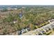 Expansive aerial view showcasing the home's surrounding community with mature trees, and a nearby pond at 7652 Channery Way, Raleigh, NC 27616