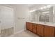 Bathroom with double vanity, wood cabinets, and a walk-in shower at 7652 Channery Way, Raleigh, NC 27616