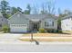 Charming single Gathering home boasts gray siding, stone accents, a two-car garage, and manicured landscaping at 7652 Channery Way, Raleigh, NC 27616