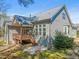 Rear view of the home featuring a deck, patio, neutral siding, well-manicured lawn, and architectural roof at 7652 Channery Way, Raleigh, NC 27616