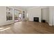Open living room with fireplace, hardwood floors, large windows, and access to the deck at 7652 Channery Way, Raleigh, NC 27616