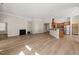 Open concept living space with fireplace, hardwood floors, and a kitchen area at 7652 Channery Way, Raleigh, NC 27616