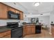 Cozy kitchen with wooden cabinets, black appliances, and an adjacent dining area at 7706 Falcon Rest Cir, Raleigh, NC 27615