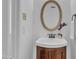 Charming bathroom features a wood vanity, updated faucet, and decorative oval mirror at 7727 Ohmann Ct, Raleigh, NC 27615
