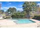 A large community swimming pool surrounded by concrete with several trees overhead at 7727 Ohmann Ct, Raleigh, NC 27615