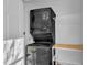 Convenient laundry area with stacked washer and dryer, plus shelving for organization at 7727 Ohmann Ct, Raleigh, NC 27615