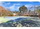 Tennis court area with blue and green surface, fencing, and lovely trees around at 7727 Ohmann Ct, Raleigh, NC 27615