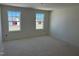 A bright, unfinished bedroom with two large windows offering natural light, awaiting flooring and personal touches at 837 Kenyon Spring Dr, Zebulon, NC 27597