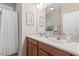 Bright bathroom with dual sinks and decorative elements, and a bathtub with curtain and storage at 9 Water Stone Ct, Durham, NC 27705