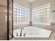 Bathroom featuring a corner soaker tub with jacuzzi jets and privacy windows with privacy windows at 9 Water Stone Ct, Durham, NC 27705