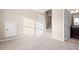 Light-filled bedroom with neutral carpet and walls, featuring a door leading to an en-suite bathroom at 9 Water Stone Ct, Durham, NC 27705