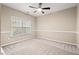 Bedroom featuring neutral walls, carpet and a ceiling fan and a large window providing natural light at 9 Water Stone Ct, Durham, NC 27705