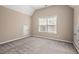Spacious bedroom with neutral walls, plush carpeting, and a window providing natural light at 9 Water Stone Ct, Durham, NC 27705